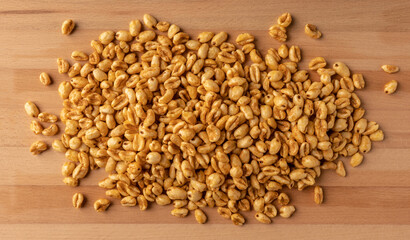 Wheat flakes on the wooden plank. Shot from above.