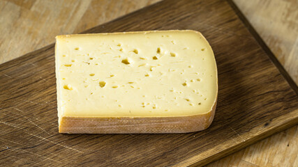 Cheese lies on a wooden board