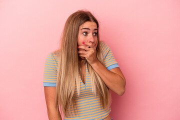 Young Russian woman isolated on pink background shocked pointing with index fingers to a copy space.