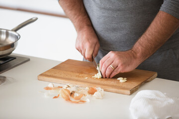 Man cutting vegetables on wooden desk in home kitchen
