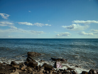Black Sea in summer, rocky coast and cloudy blue sky, seascape