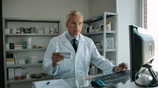 Working Caucasian Employee Pharmacist Checking Client Order By Id In Drug Store 