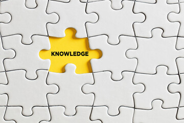 Fototapeta premium The word knowledge written on missing puzzle piece.