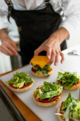 Technique for making cheeseburgers at home. The chef assembles the finished dish.