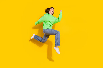 Fototapeta na wymiar Full body profile side photo of attractive young happy woman jump up run sale isolated on yellow color background