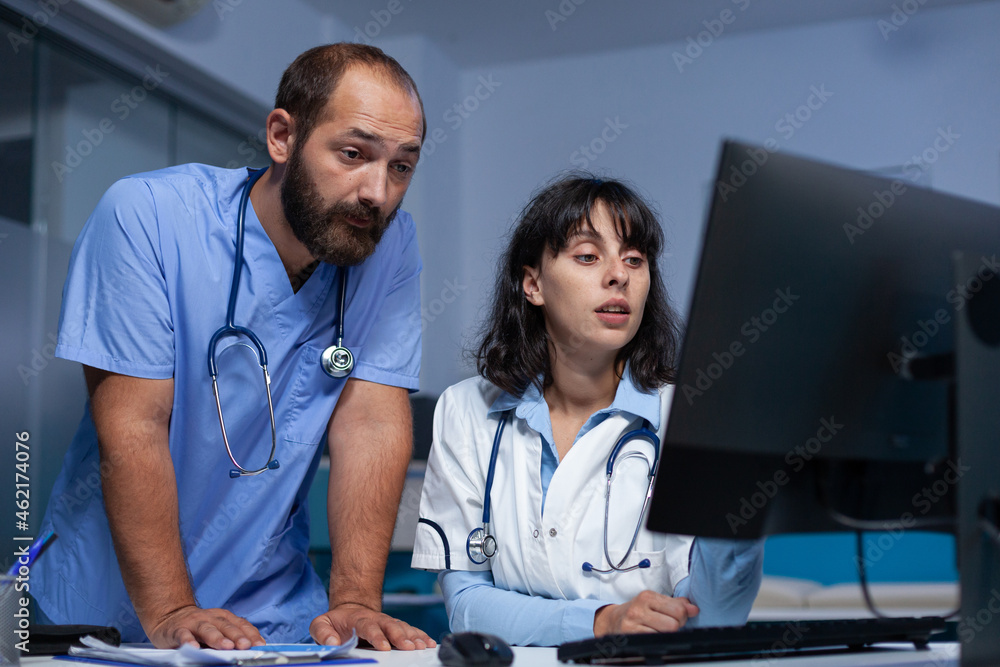 Aufkleber medic and man assistant looking at computer display after hours. specialist and nurse using technolo