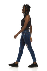 Black woman in casual clothes is walking and talking. Full length, side view. - 462175273