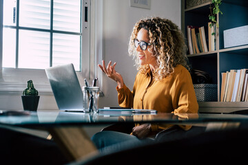 Smiling businesswoman gesturing during video conference through laptop at home