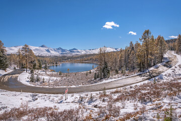 road asphalt mountains snow lake autumn trees forest steep curve