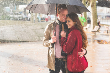 Happy couple with umbrella on a rainy day in London