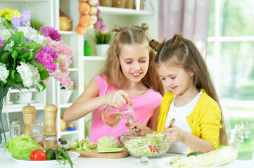 Portrait of cute girls preparing delicious fresh salad