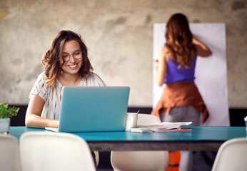 Young woman is in a good mood while working in the office