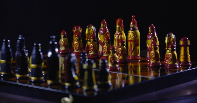 Chessboard close-up. Two unrecognizable persons in white cloth gloves play chess, move pieces and make moves