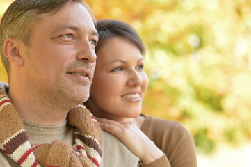 Happy couple posing in autumnal park outdoors