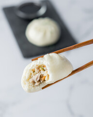 Chopsticks picking dumplings stuffed with meat and vegetables with a bite