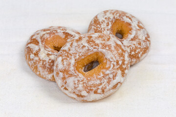 Glazed ring shaped spice cookies on fabric napkin, close-up