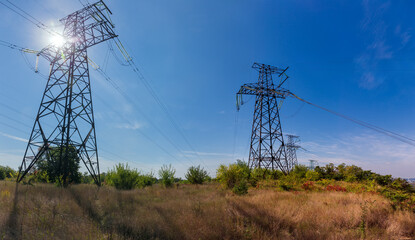 Lattice steel anchor transmission towers of overhead power lines backlit