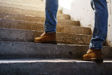 Close up of man walking up on concrete staircase