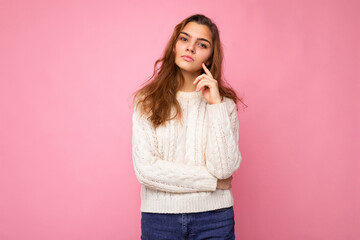 Portrait of young attractive caucasian hipster woman in trendy casual clothes. Sexy carefree female person posing isolated near pink wall in studio. Positive self-confident serious model with natural