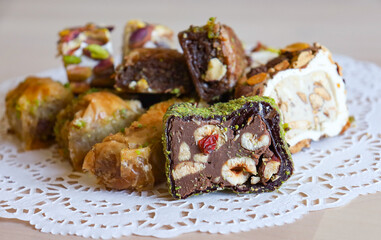 traditional Turkish sweets, baklava, lies on a beautiful napkin on the table. Treats, delicacies, nuts, nougat. Turkish sweets