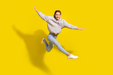 Fototapeta na wymiar Full size photo of funny brown hair millennial lady jump wear sweater jeans sneakers isolated on yellow background