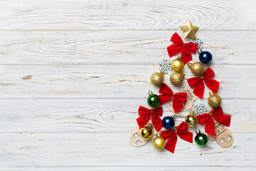 Christmas tree made from colored ball decoration on colored background, view from above. New Year minimal concept with copy space