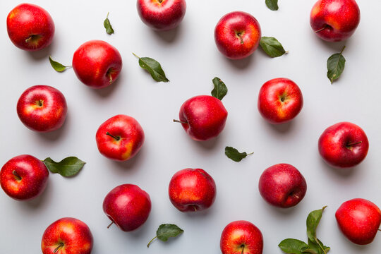 Many red apples on colored background, top view. Autumn pattern with fresh apple above view