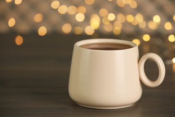 Obraz na płótnie Canvas Cup of tasty freshly brewed tea on wooden table, closeup