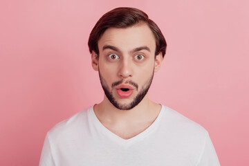 Portrait of shocked funny excited guy open mouth omg reaction on pink background