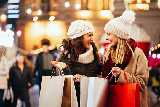 Happy women friends are shopping for presents at Christmas. People holiday sale shopping concept
