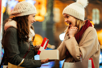Happy women friends exchanging gifts for Christmas. Shopping happiness sale people concept