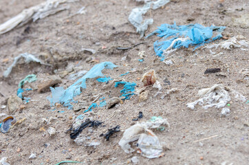Closeup shot of plastic rubbish thrown in the sand - the concept of pollution