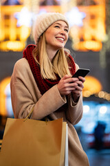 Shopper woman buying online on the smart phone at Christmas. People shopping communication concept