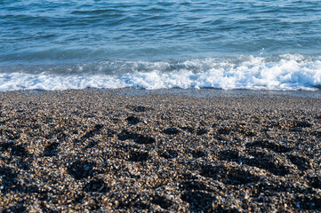 Pebble beach with surf crashing in the background.