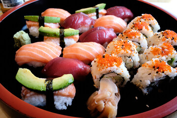 Japanese sushi food. Maki and rolls with tuna, salmon, shrimp, crab and avocado. Top view of the sushi assortment. Rainbow sushi roll, uramaki, hosomaki and nigiri.
