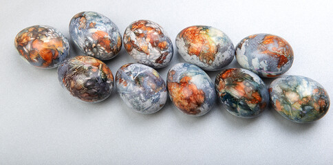 Colorful easter eggs row painted in natural products blueberries and onion peels, isolated on gray background