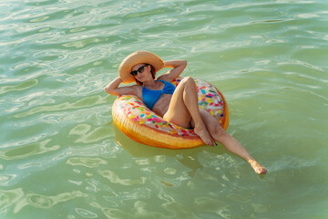 Rest. A woman floats on an inflatable ring in the lake.