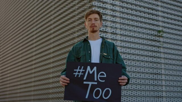Caucasian man holding banner with hashtag Me too