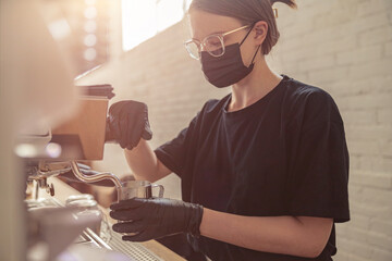 Cute woman working with coffee machine in cafeteria