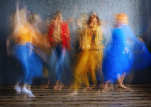 Women in multi colored dress dancing on floor in studio
