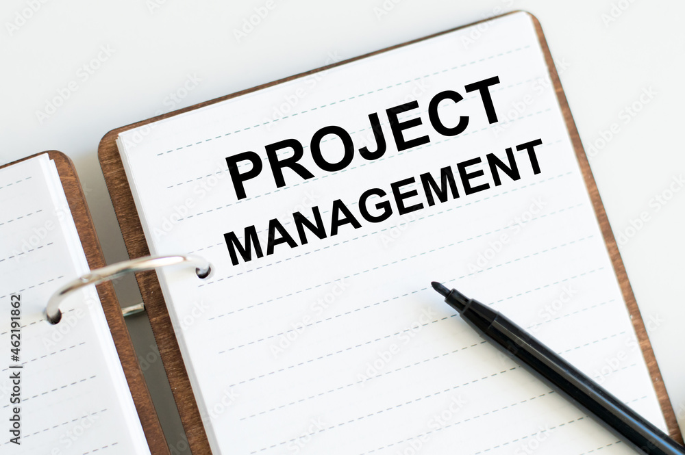 Poster notebook with text project management beside black marker