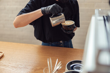 Professional barista is making fresh takeaway latte
