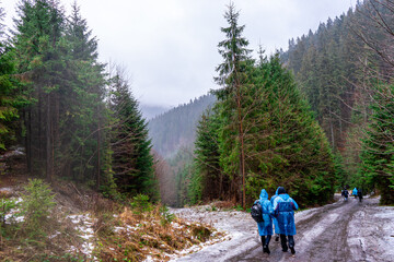 Fototapeta na wymiar People on raincoats on ice road, the Carpathian Mountains, Ukraine