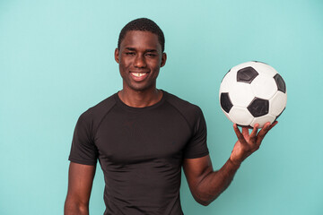 Young African American man playing football isolated on blue background happy, smiling and cheerful.