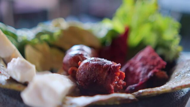 White cheese slices, lettuce, chorizo, and roasted nopales in Mexican molcajete