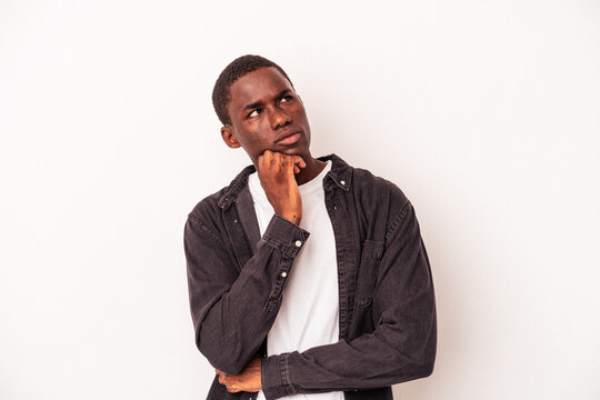 Young African American man isolated on white background thinking and looking up, being reflective, contemplating, having a fantasy.