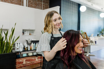 Hairstylist giving a haircut to a customer at a beauty salon - Powered by Adobe