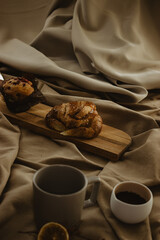 Croissant and cupcake with a mediterranean breakfast in a background beige isolated. Space for copying and concept coffee.