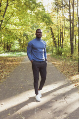 African american student walking in the park in autumn season