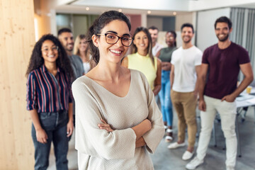 Successful business team posing for presentation of work while looking at camera in a coworking space.